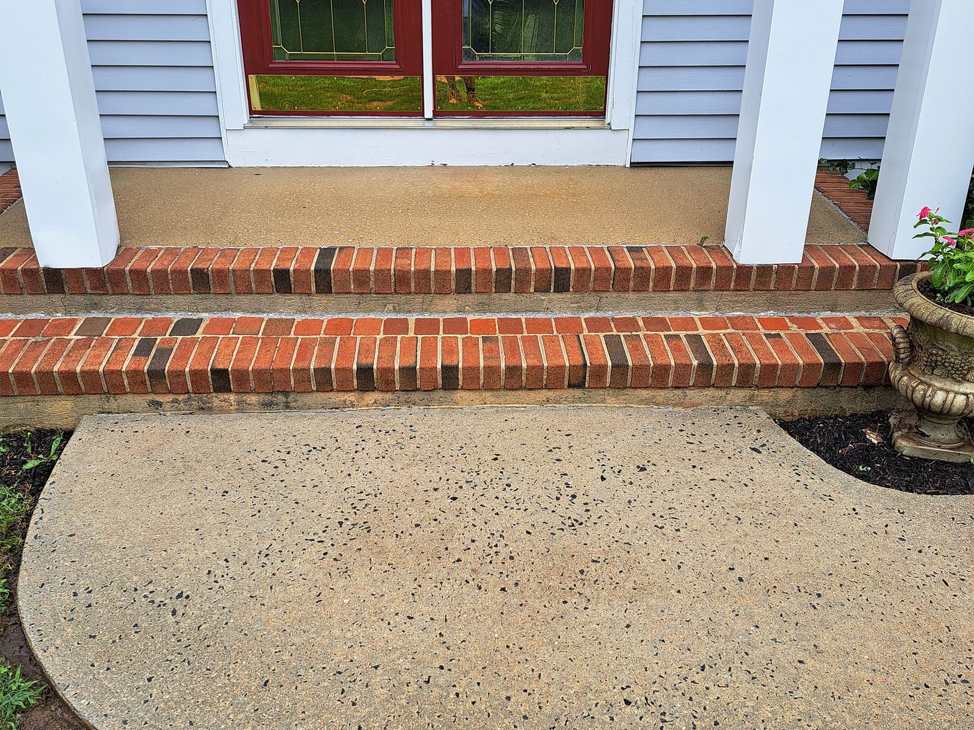 A brick walkway leading to the front door of a house.