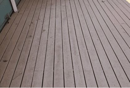 A wooden deck with a blue building in the background