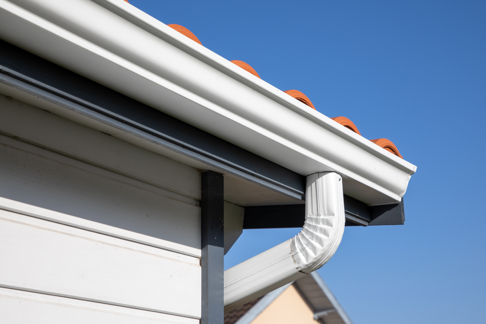 A close up of a gutter on the side of a house.