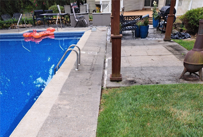 A swimming pool with a fire pit in the backyard