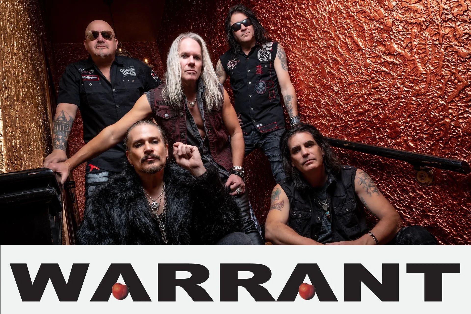 Warrant band members posed together on stairs. The band name is below in a black and red font.
