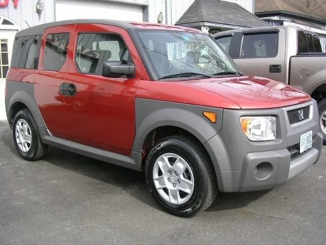 Red compact SUV parked on a lot, showing a side-front view with gray trim and silver wheels