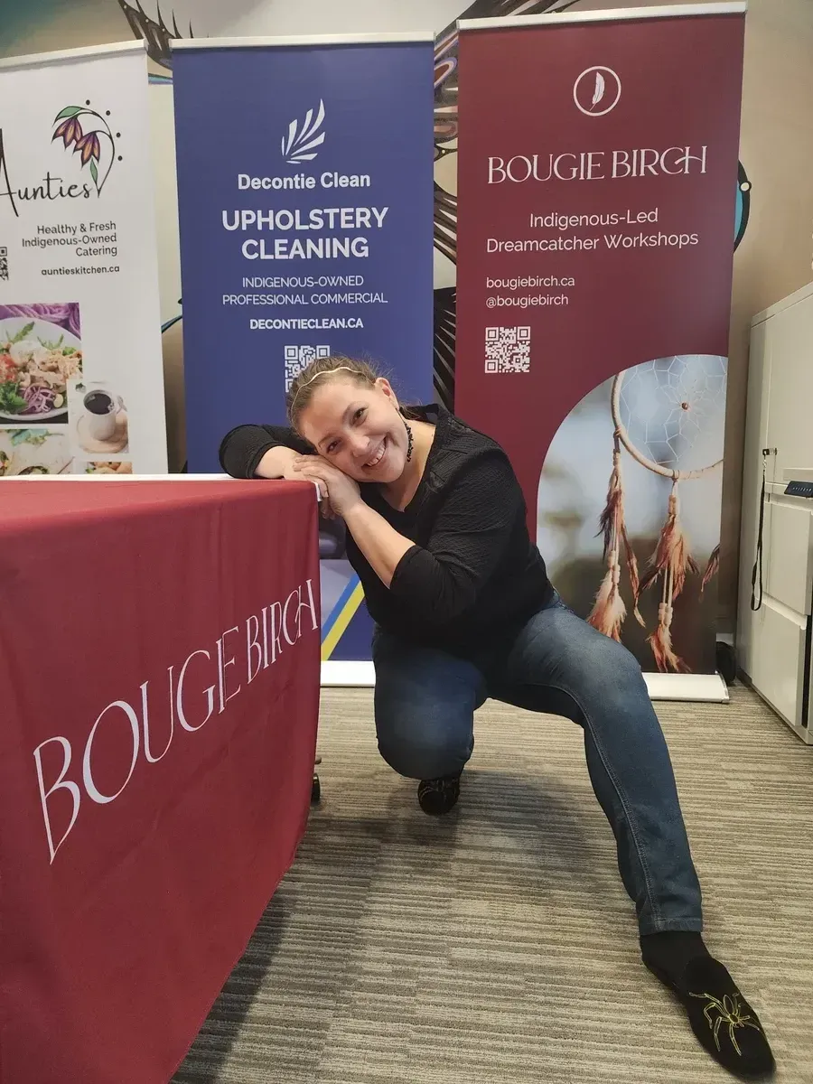 Woman smiling, posing next to a table with 