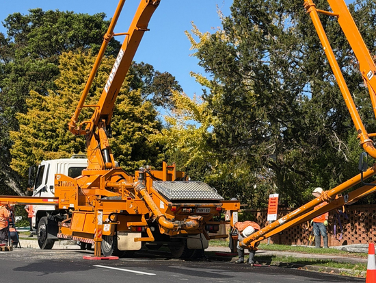Road construction involving a boom truck crane.