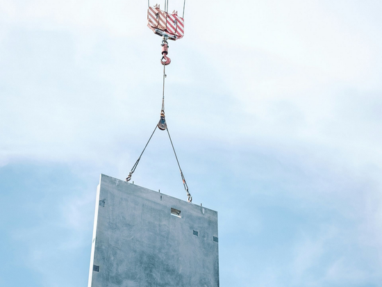 Crane lifting a precast concrete slab.