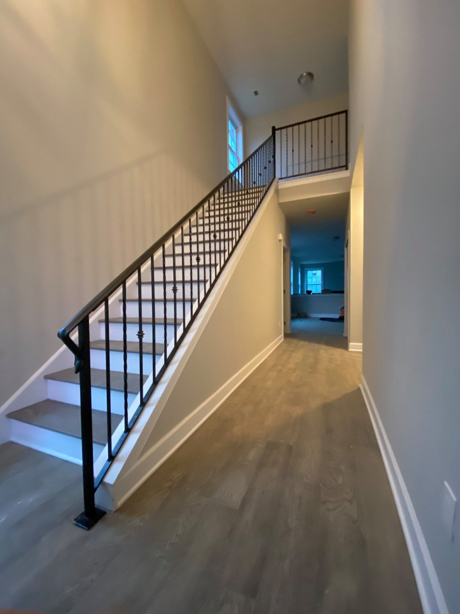 A hallway with stairs leading up to the second floor of a house.