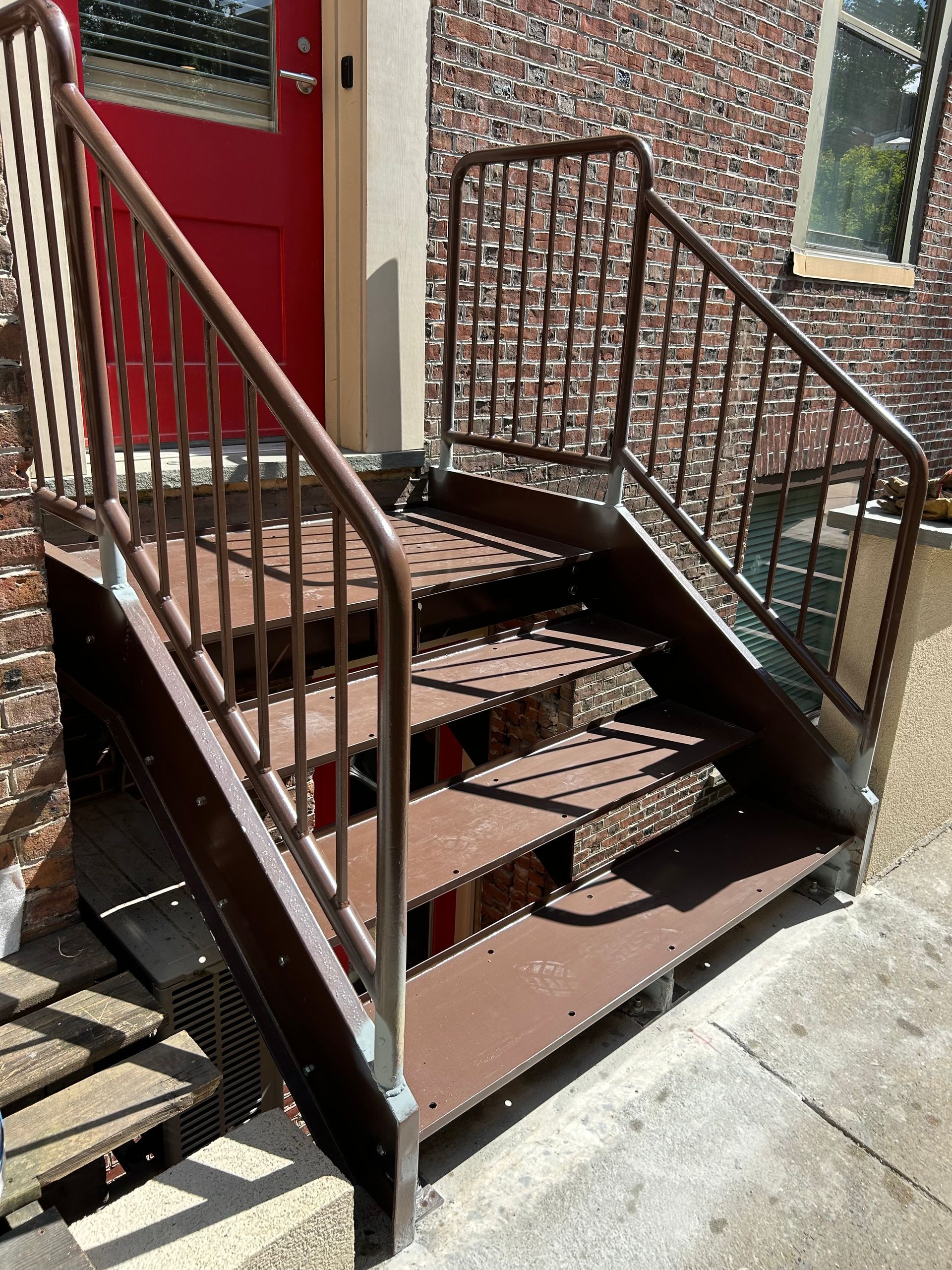A set of stairs leading up to a red door.