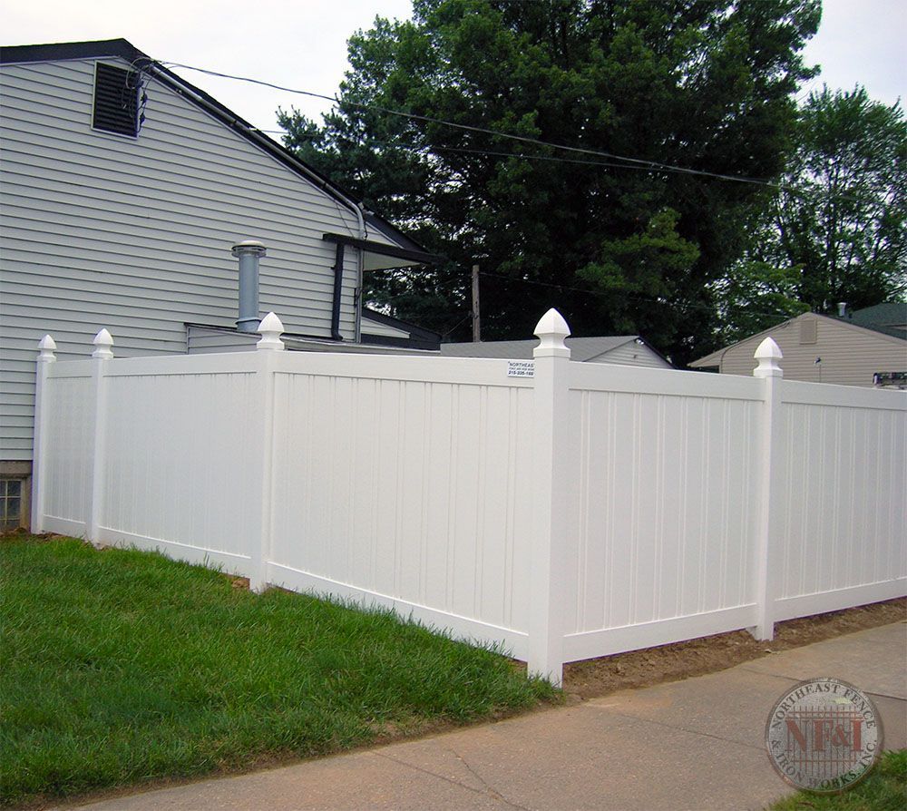 A white fence with a house in the background