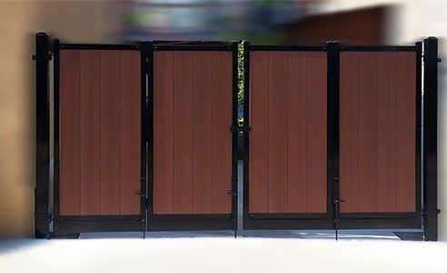 A wooden gate with a black frame is sitting in front of a building.