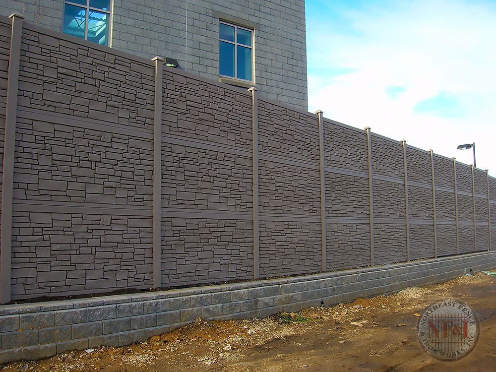 A brick wall with a fence in front of it