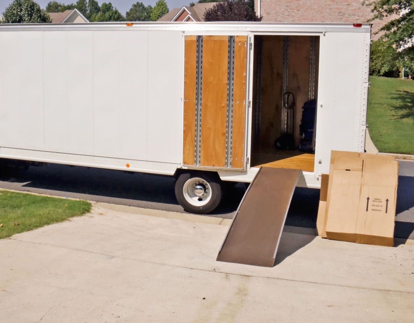 Un camion de déménagement est garé dans une allée avec la porte ouverte