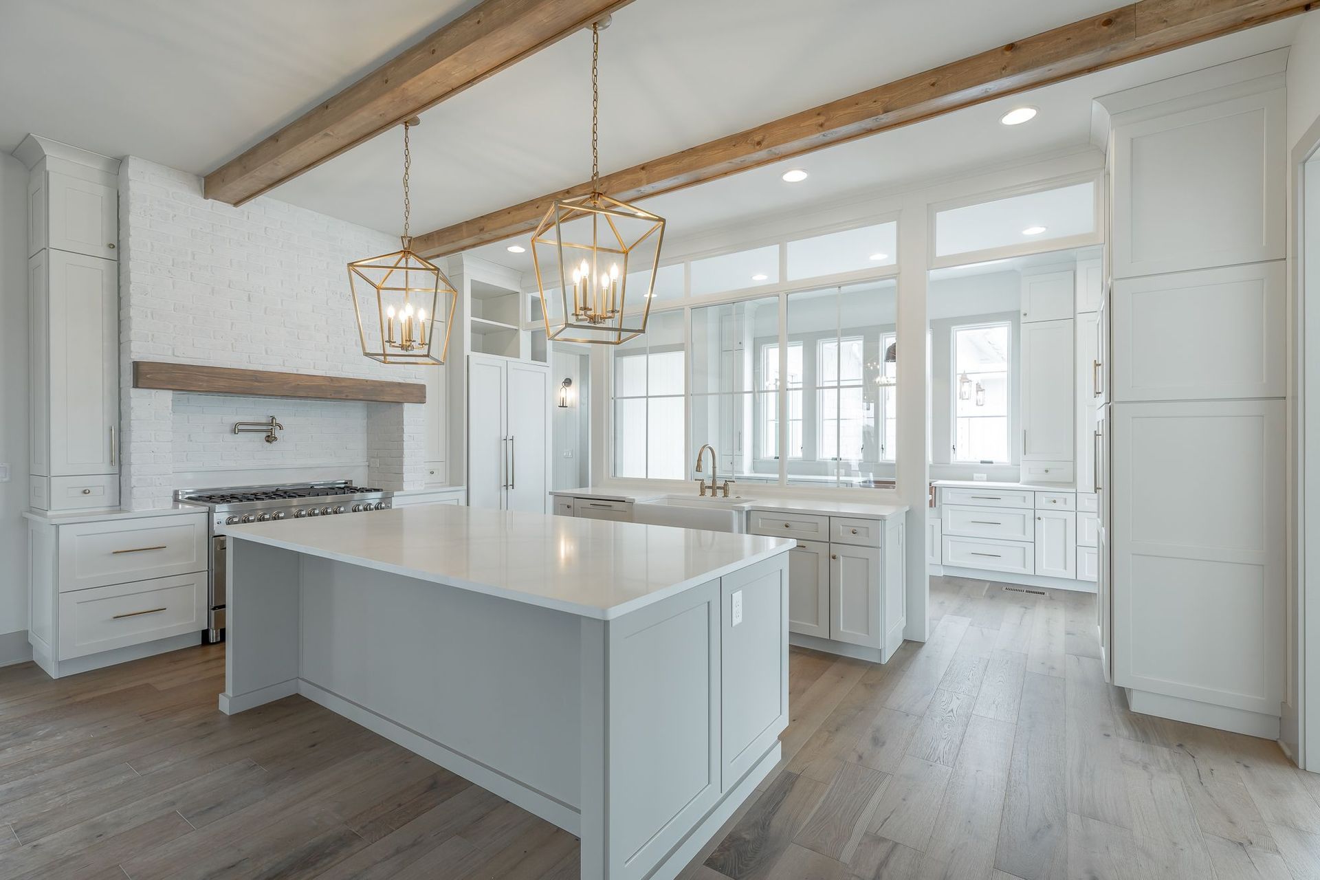 A kitchen with white cabinets and a large island in the middle.