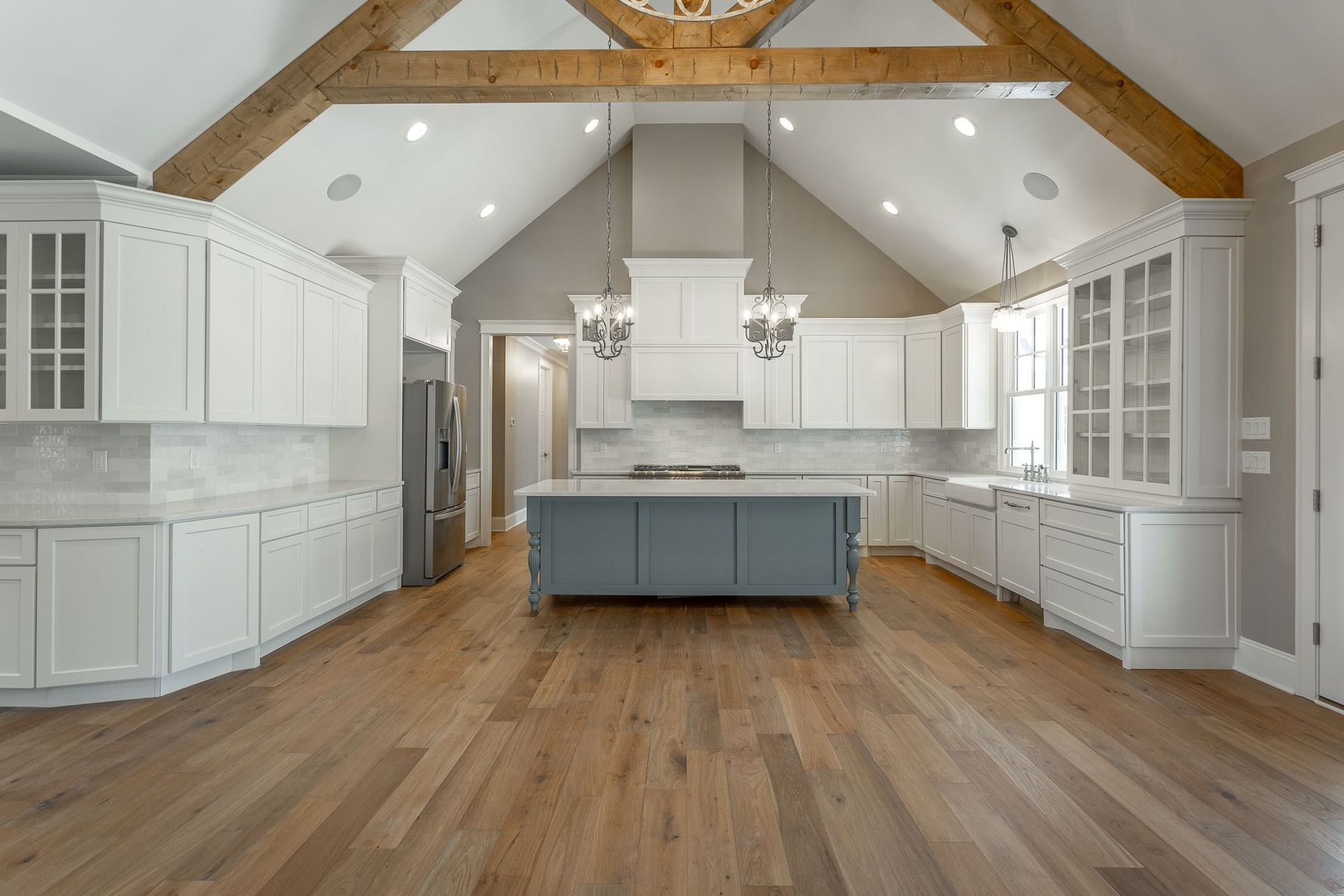 a large kitchen with white cabinets and a large island in the middle .