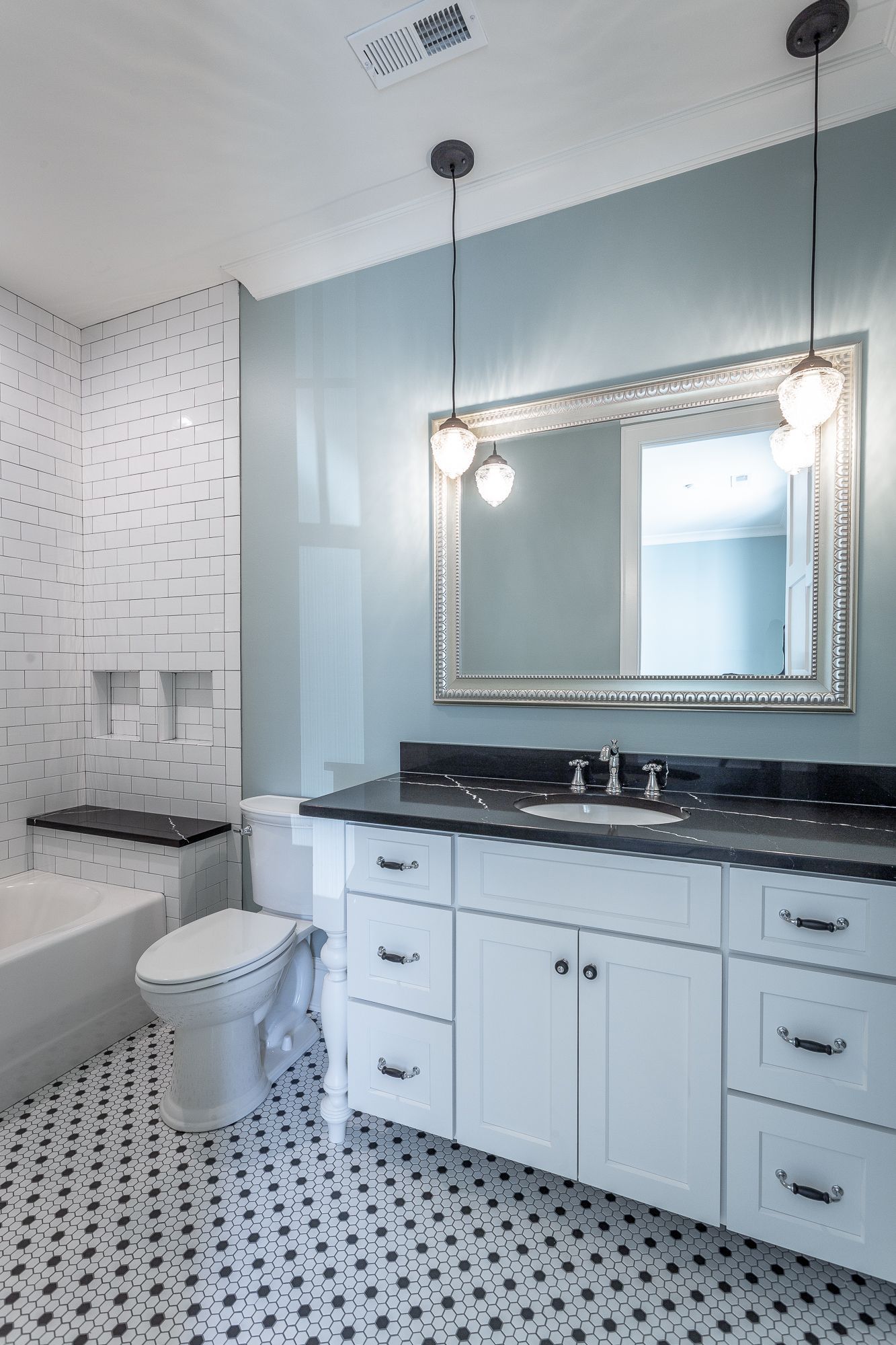 a bathroom with a toilet , sink , mirror and bathtub .
