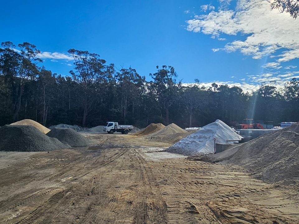 Truck in a gravel yard with piles of different coloured materials - Palms Landscape Supplies in Forster, NSW