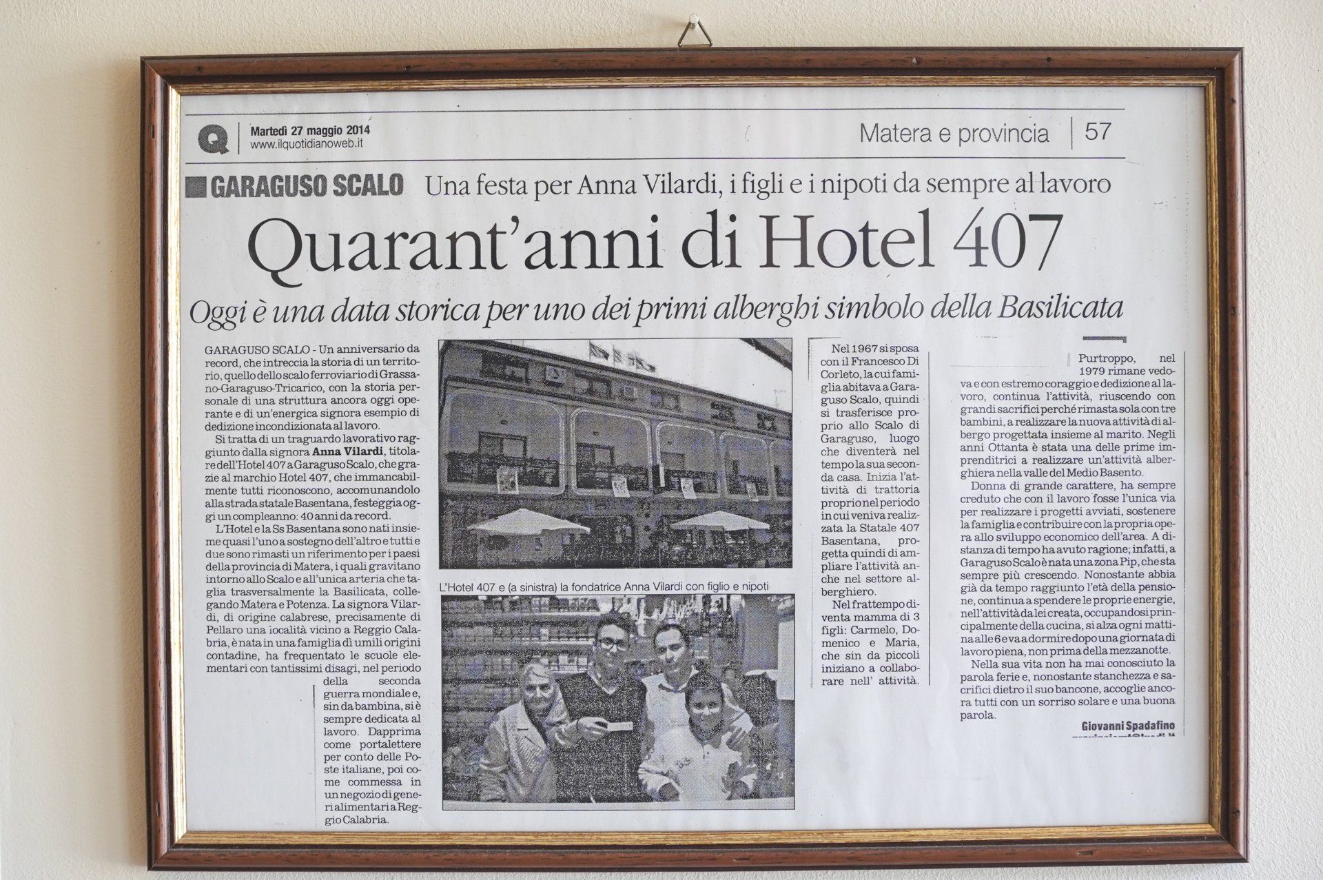 Articolo di giornale incorniciato che celebra l'anniversario dell'Hotel 407, con una foto dell'hotel.