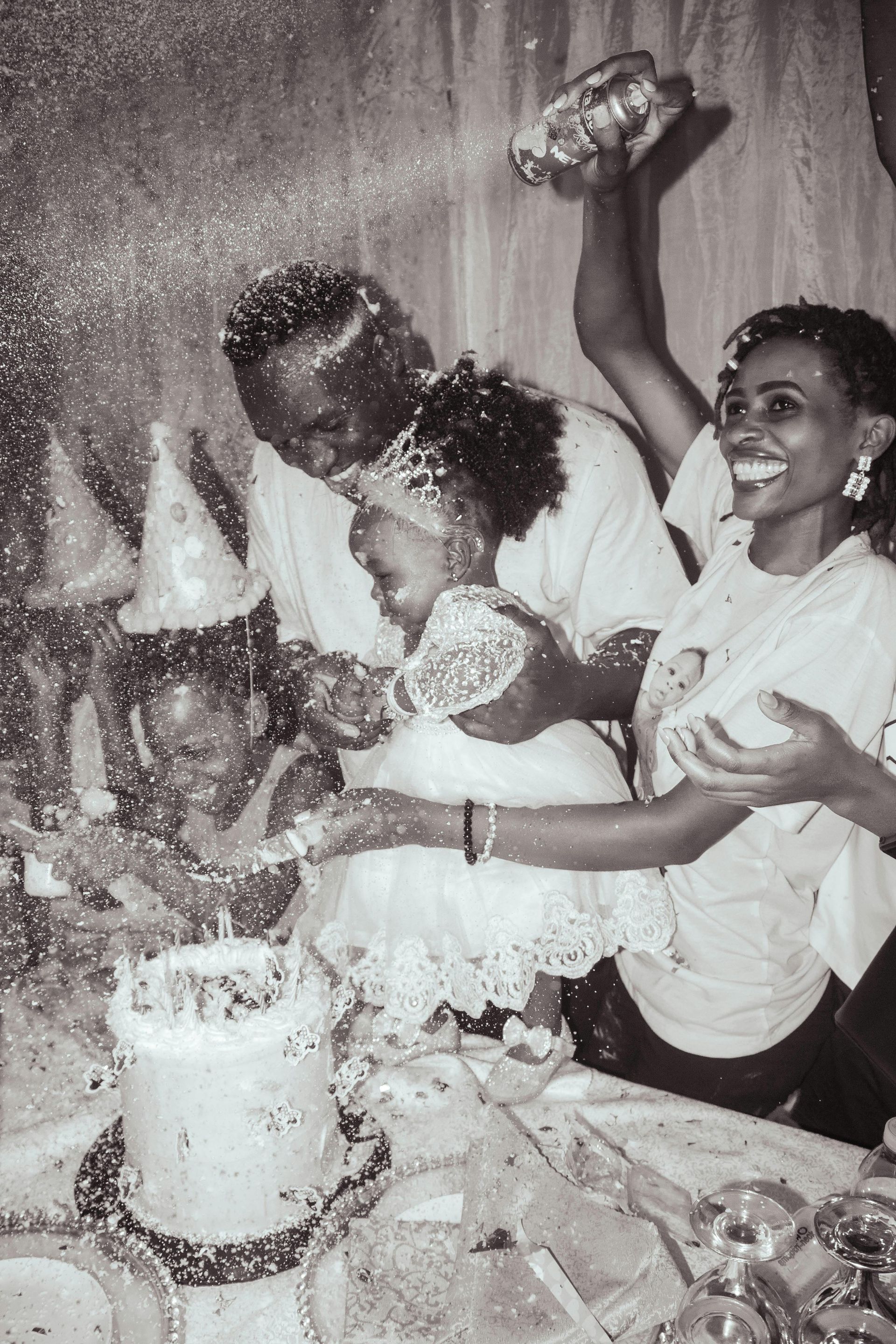 A black and white photo of a group of people celebrating a birthday.
