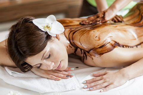 Eine Frau bekommt in einem Spa eine Schokoladenmassage.
