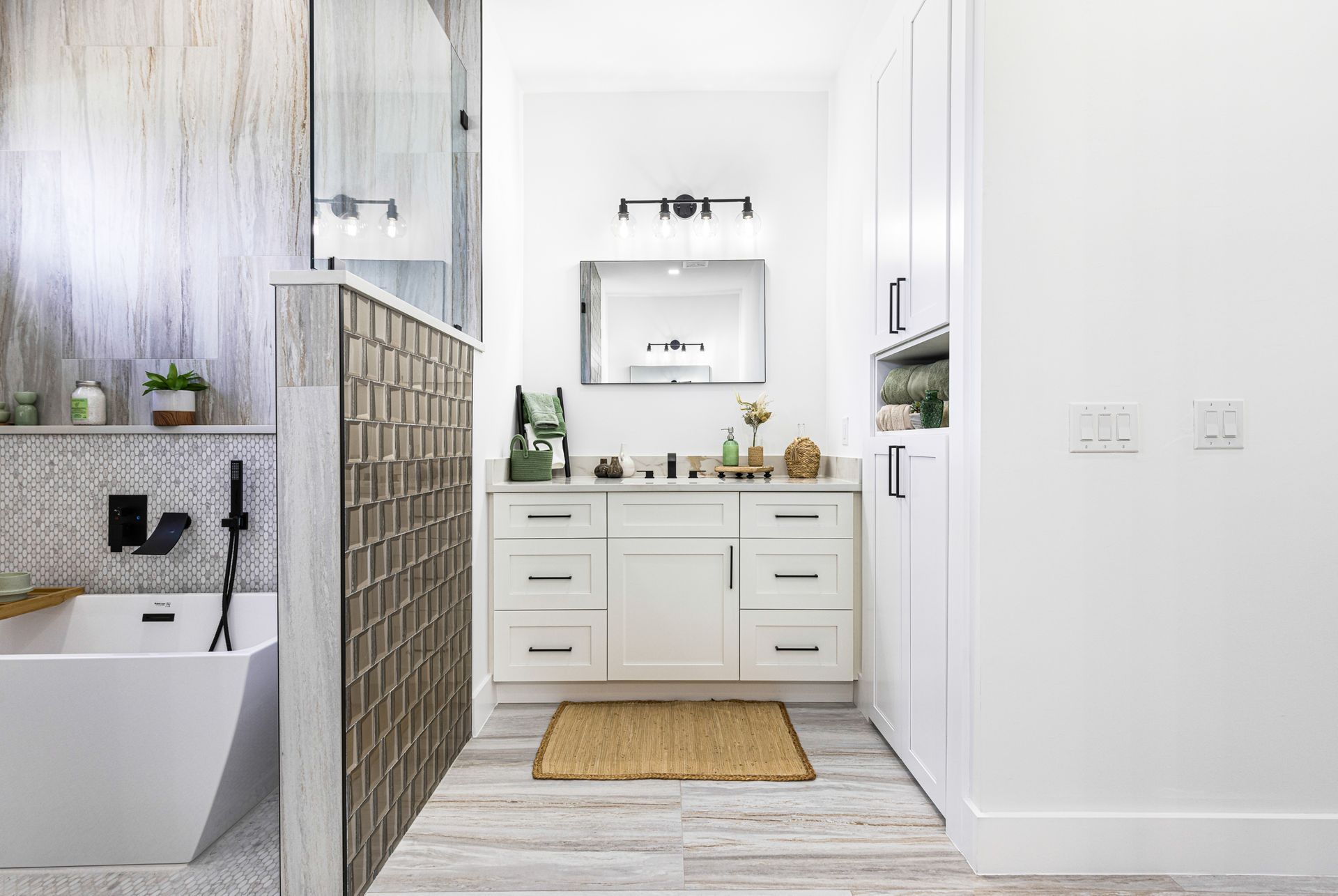 Bright white bathroom with tub, vanity, glass wall, and wood-look floors.
