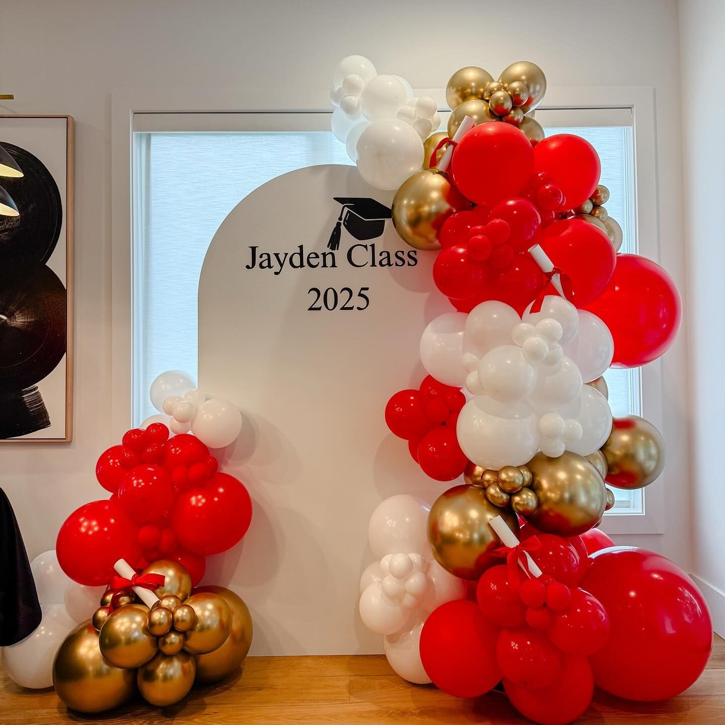 A room filled with red , white and gold balloons.