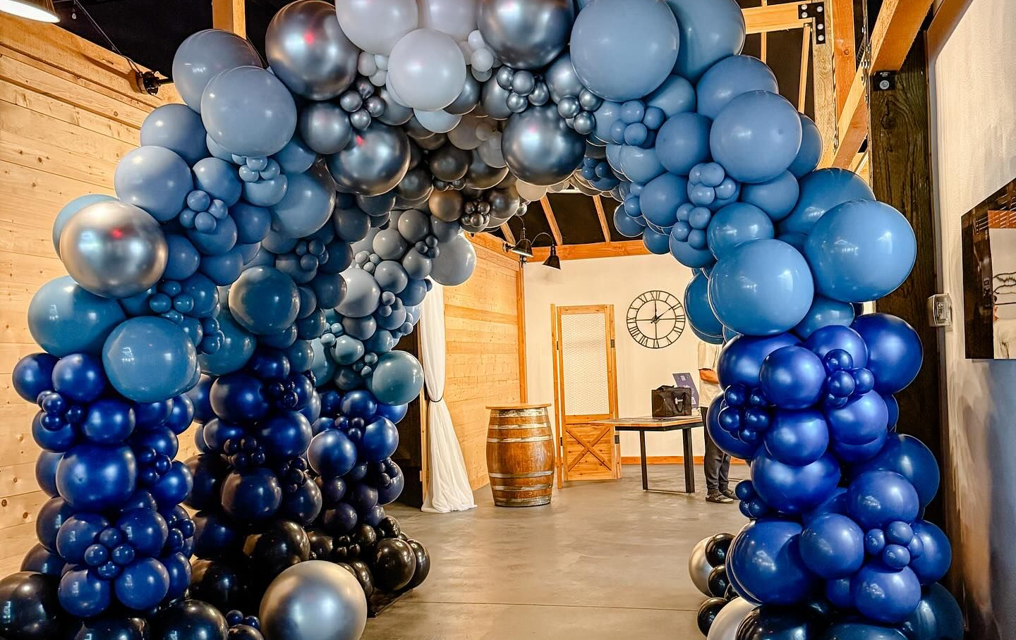 Blue and silver balloon archway frames an indoor entrance.