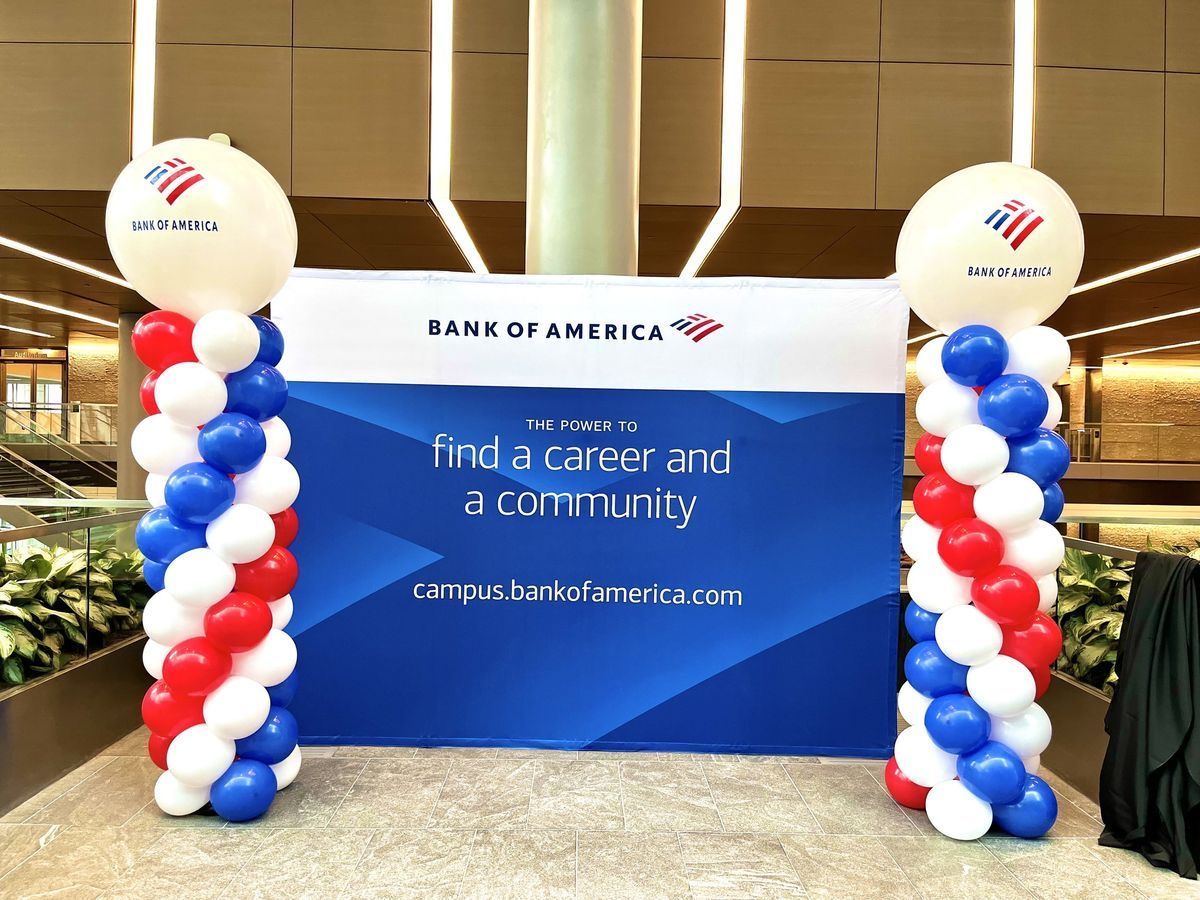 Bank of America recruitment display with red, white, and blue balloon columns and sign, 