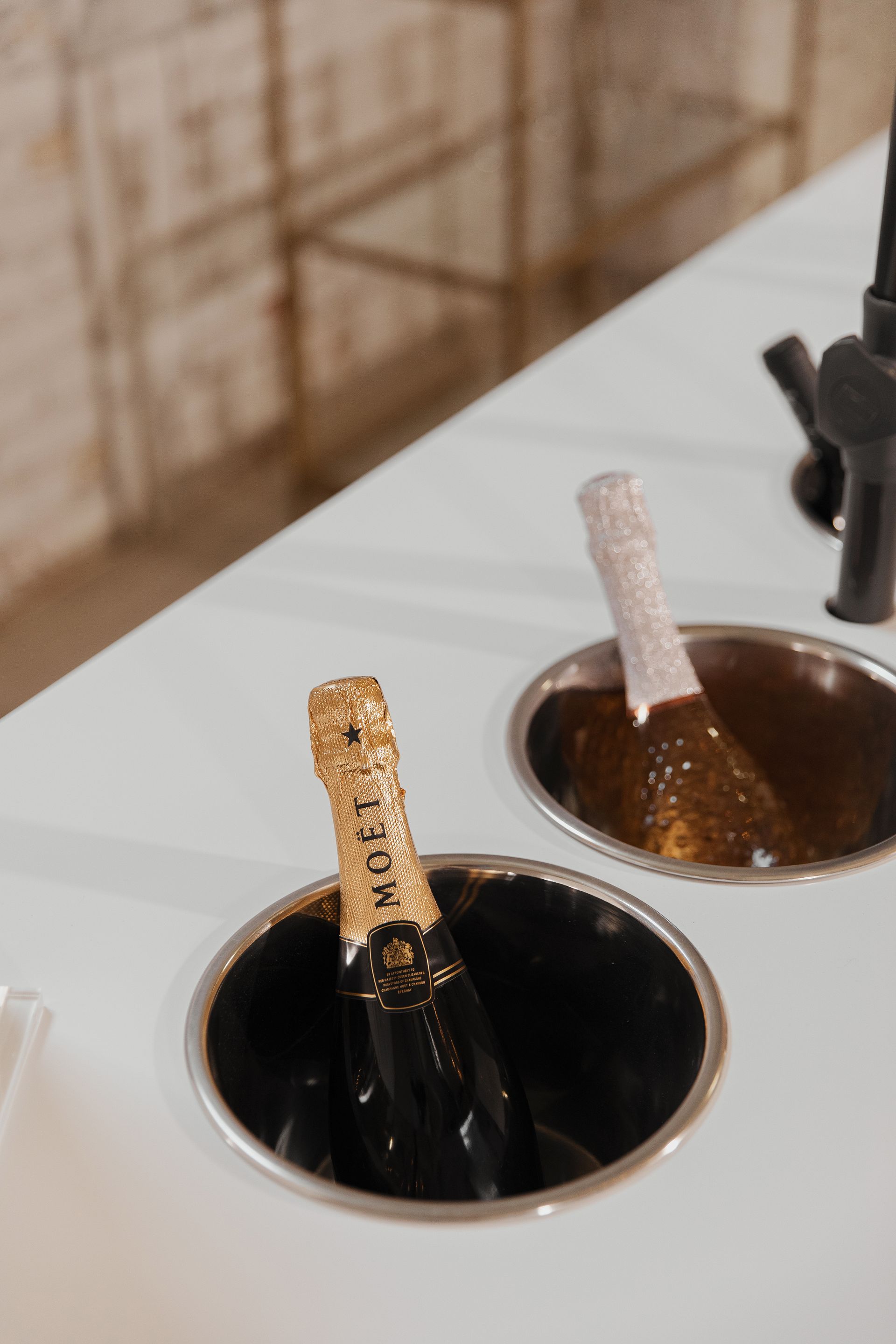 A bottle of champagne is sitting in a bucket of ice.