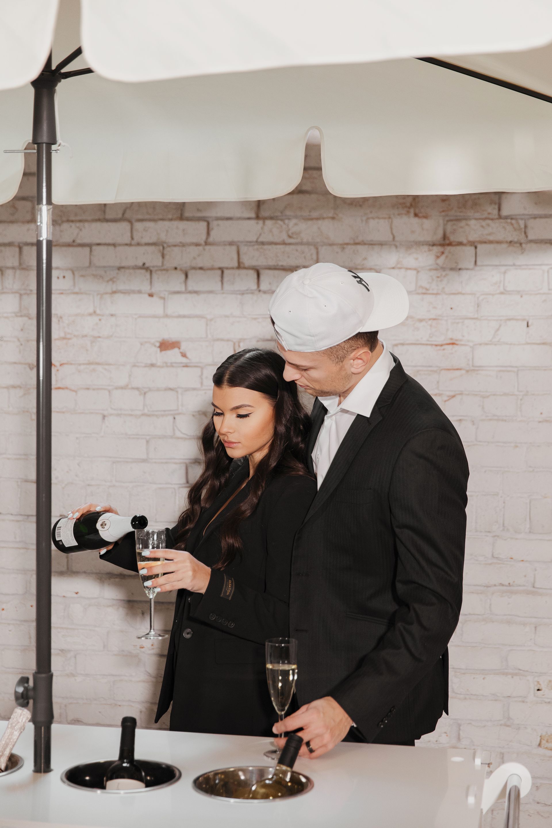 A man is pouring champagne into a glass for a woman.