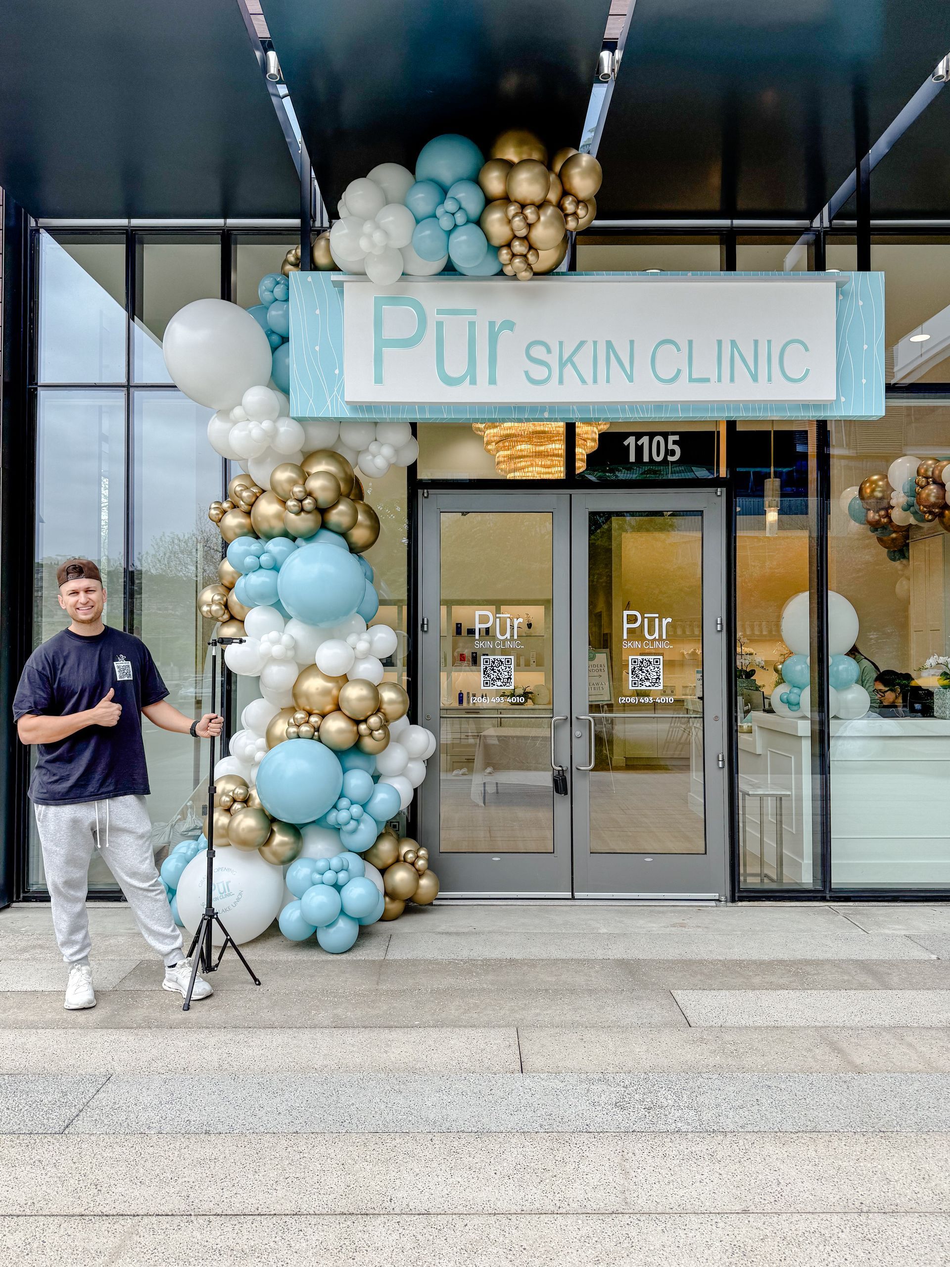 The entrance to the museum of illusions is decorated with blue and white balloons.