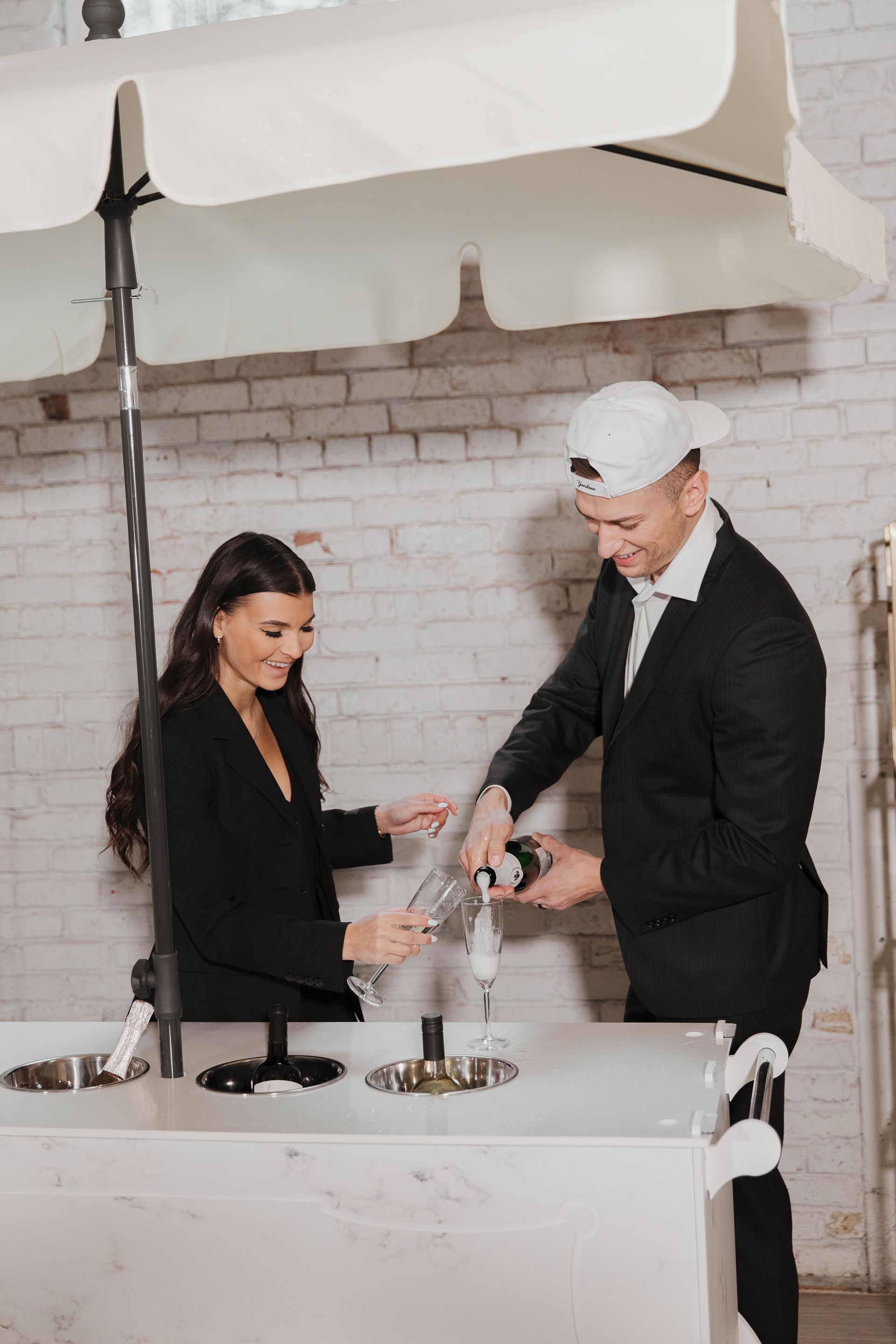 A man and a woman are standing next to each other at a bar.