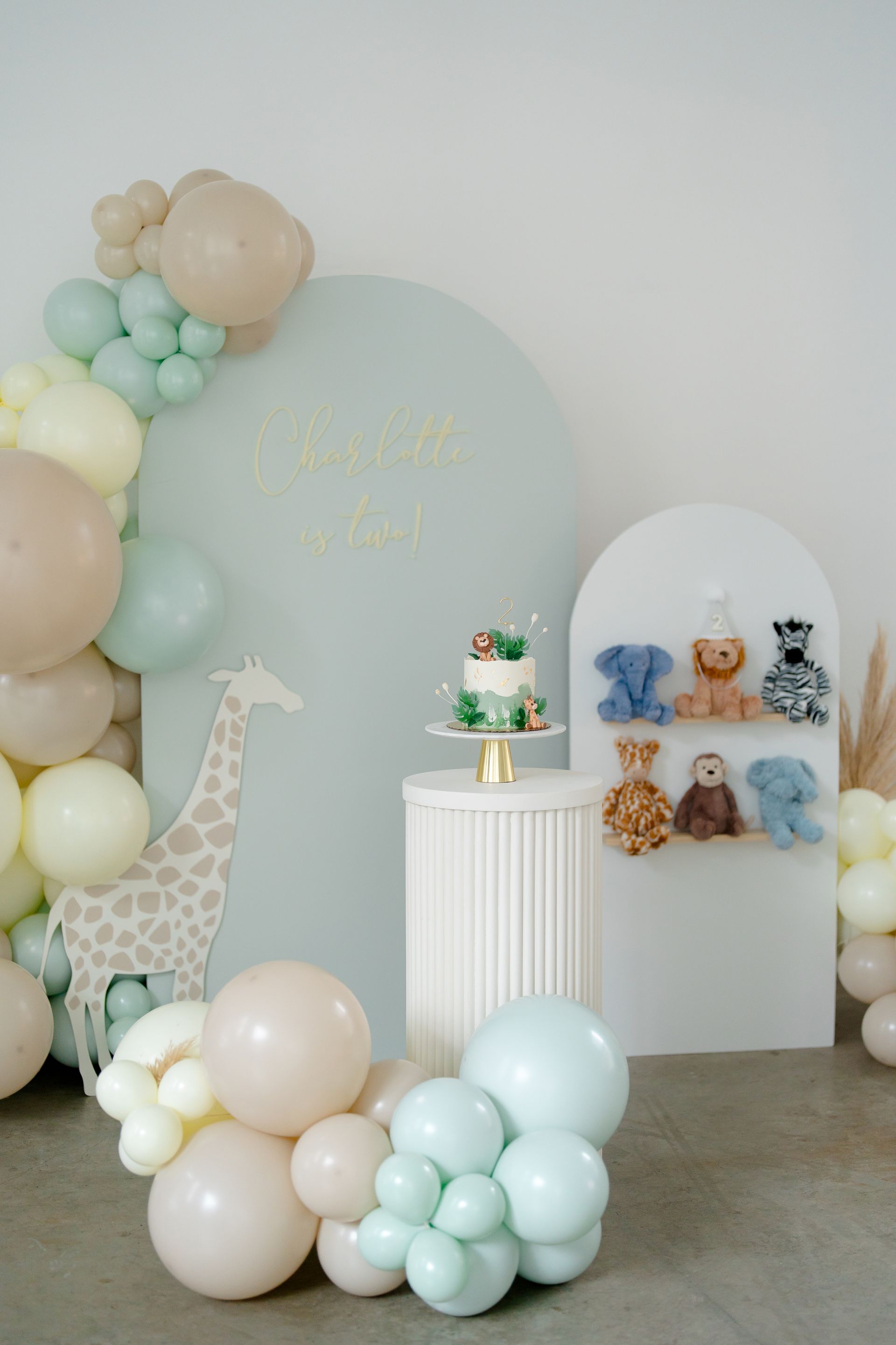 A room decorated with balloons and stuffed animals for a baby shower.