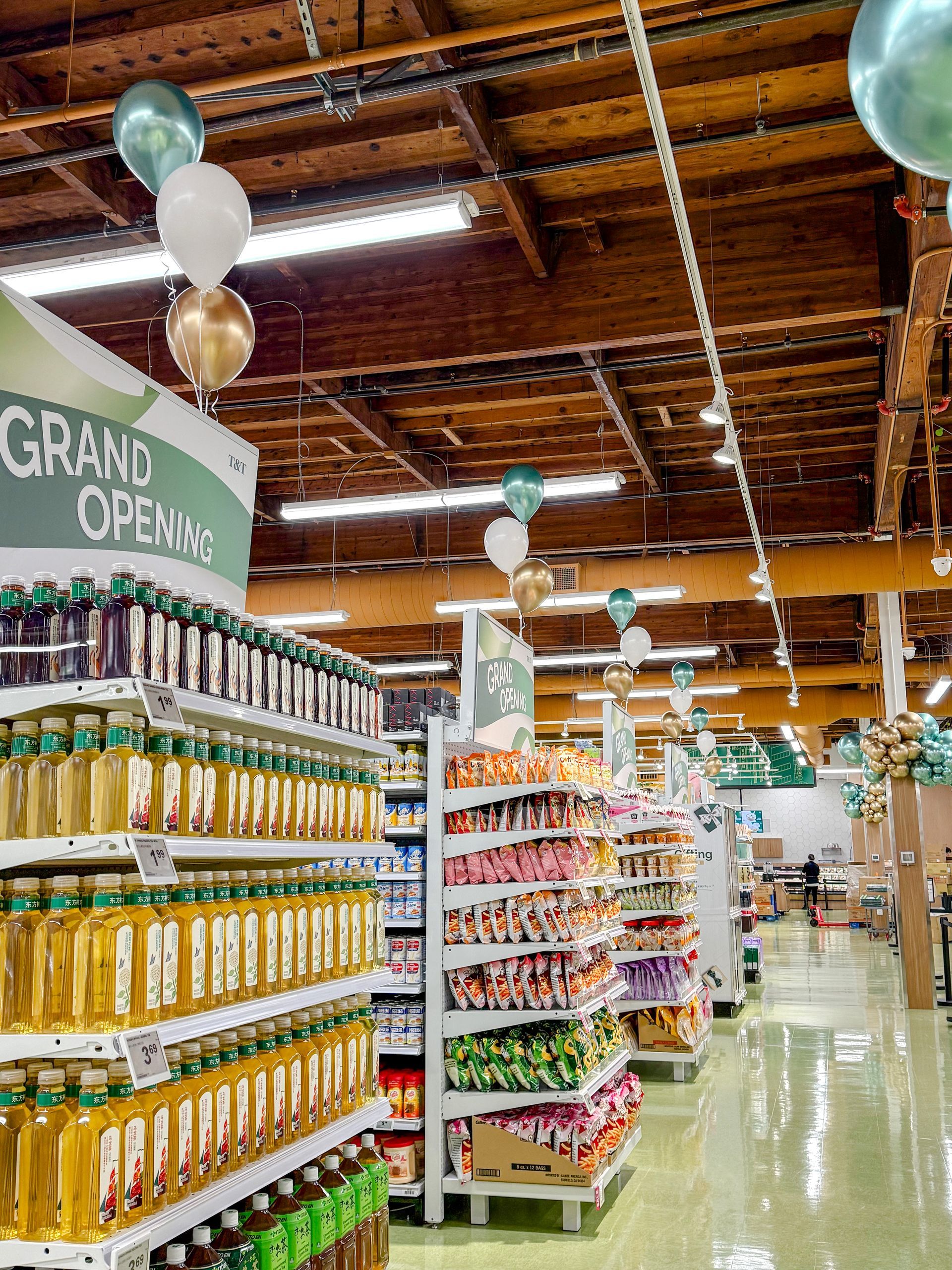 A grocery store is decorated for a grand opening with balloons hanging from the ceiling.