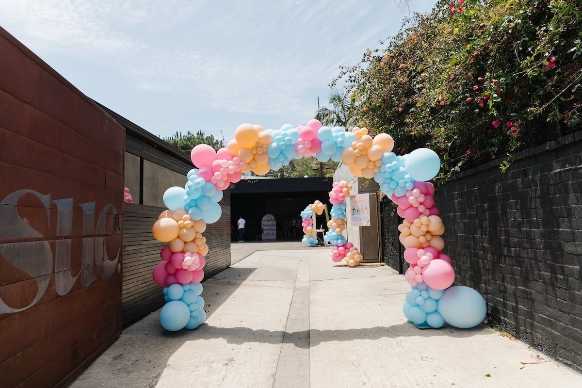 A balloon arch is sitting on the side of a road.