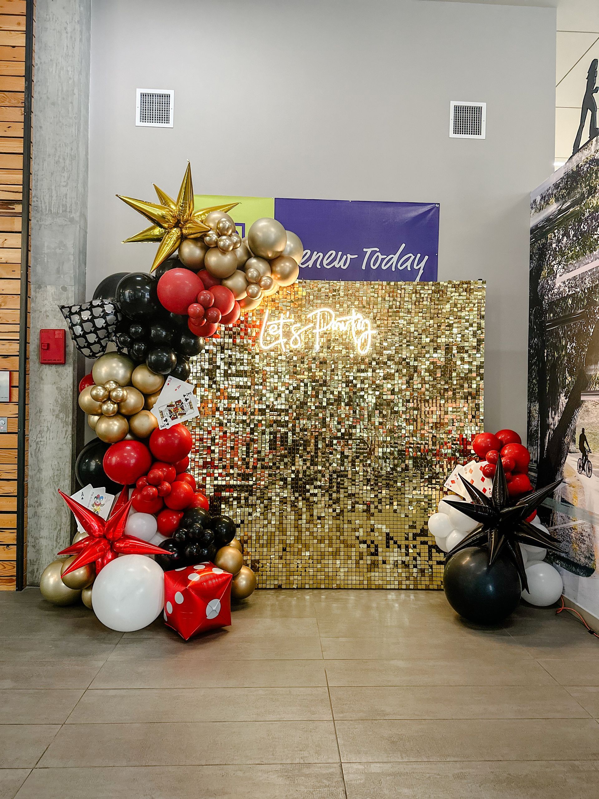 A room filled with balloons and a gold wall.