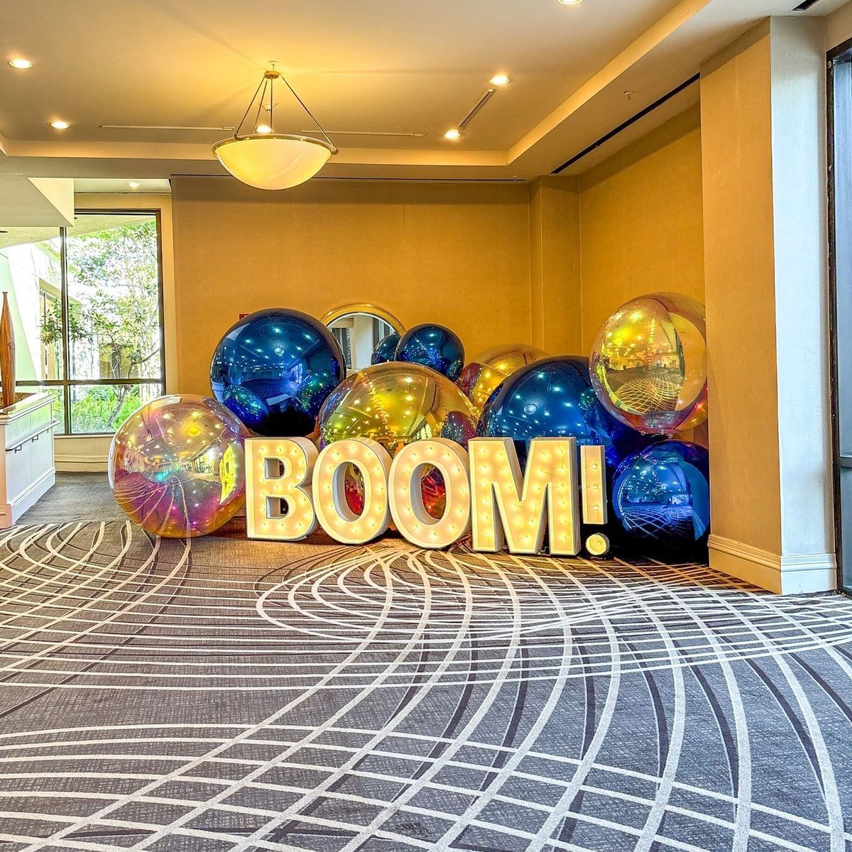 “BOOM!” balloon display with colorful balloons in a bright lobby corridor