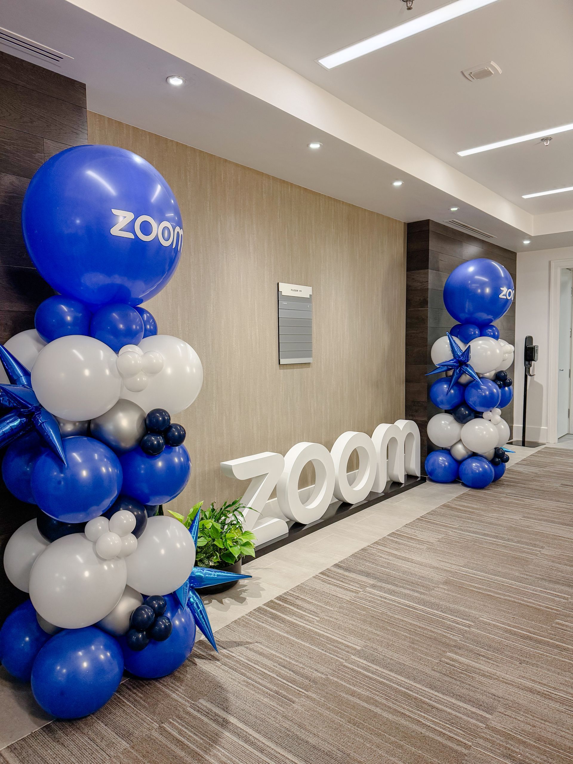 Zoom logo and balloon decorations in an office hallway.