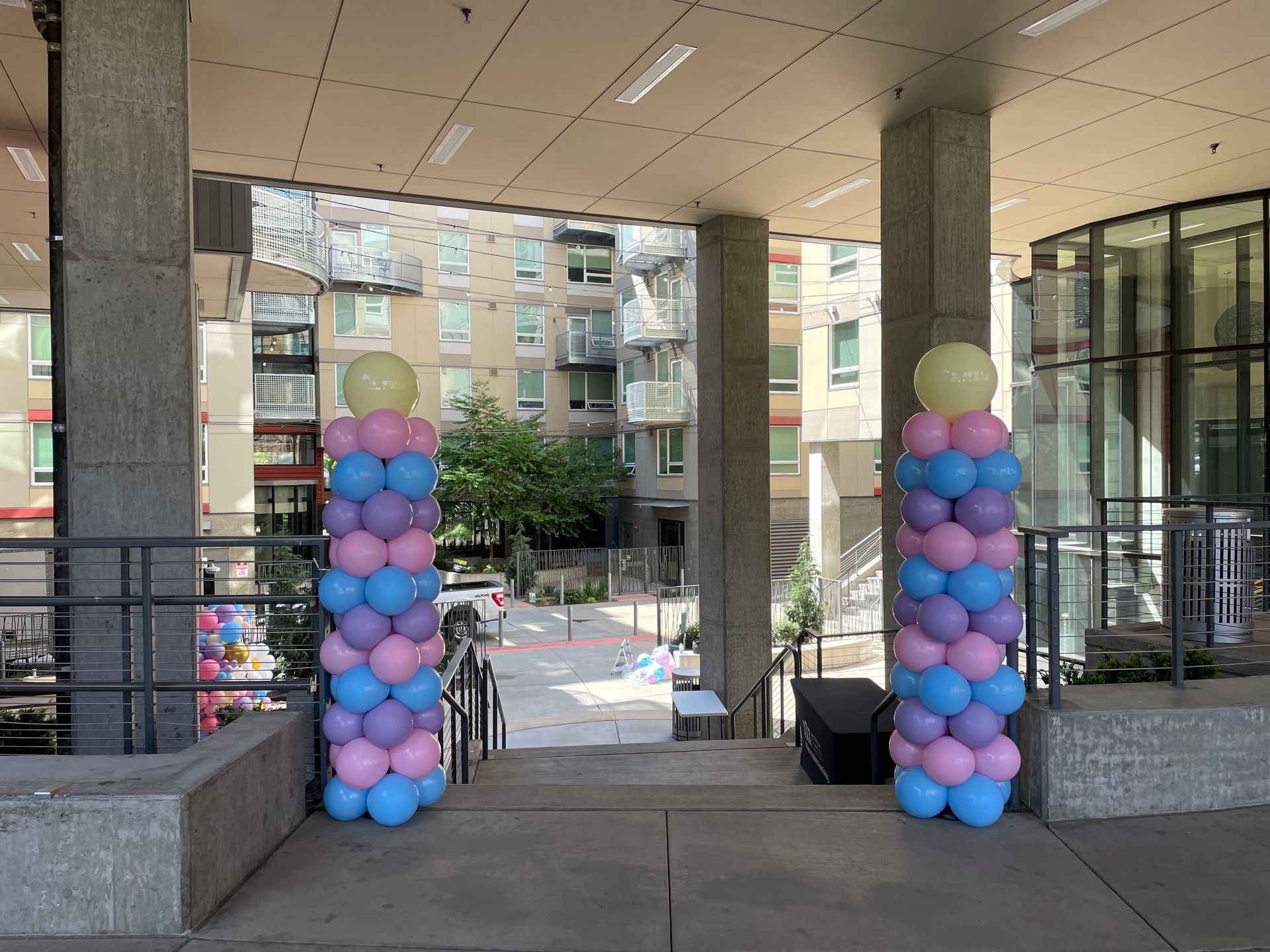 Entrance decorated with pastel balloon columns on either side of a covered walkway