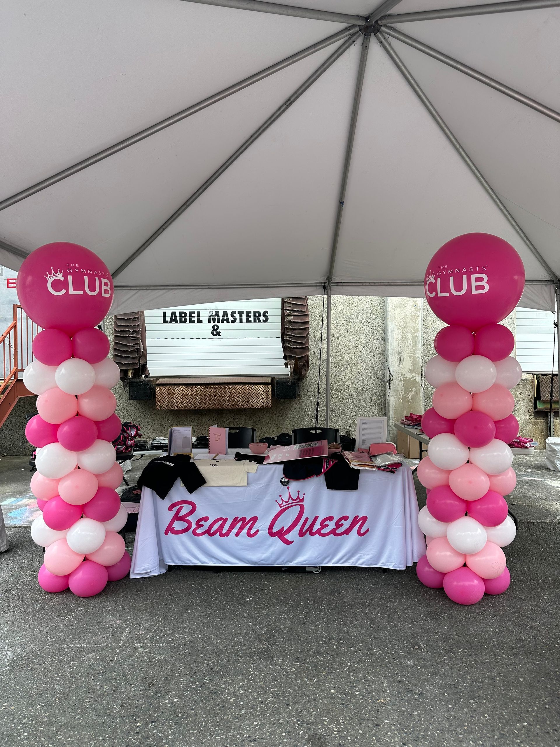 A vendor booth under a white canopy with a 