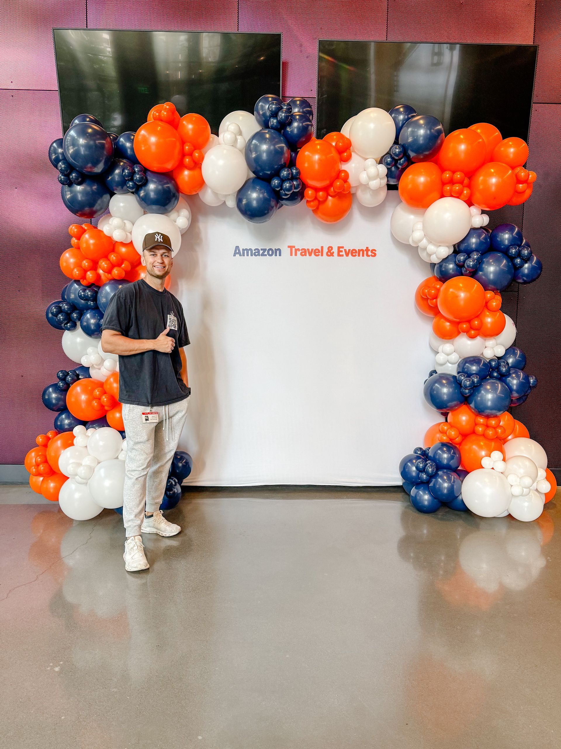 A statue of a lion is surrounded by balloons in a room.