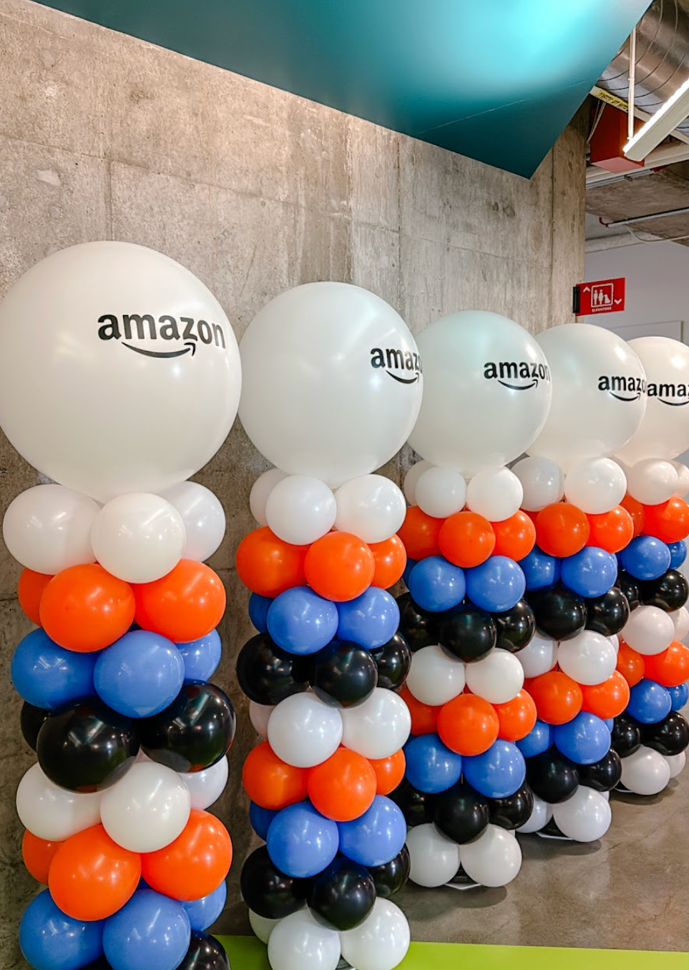 A wall covered in black , white and green balloons