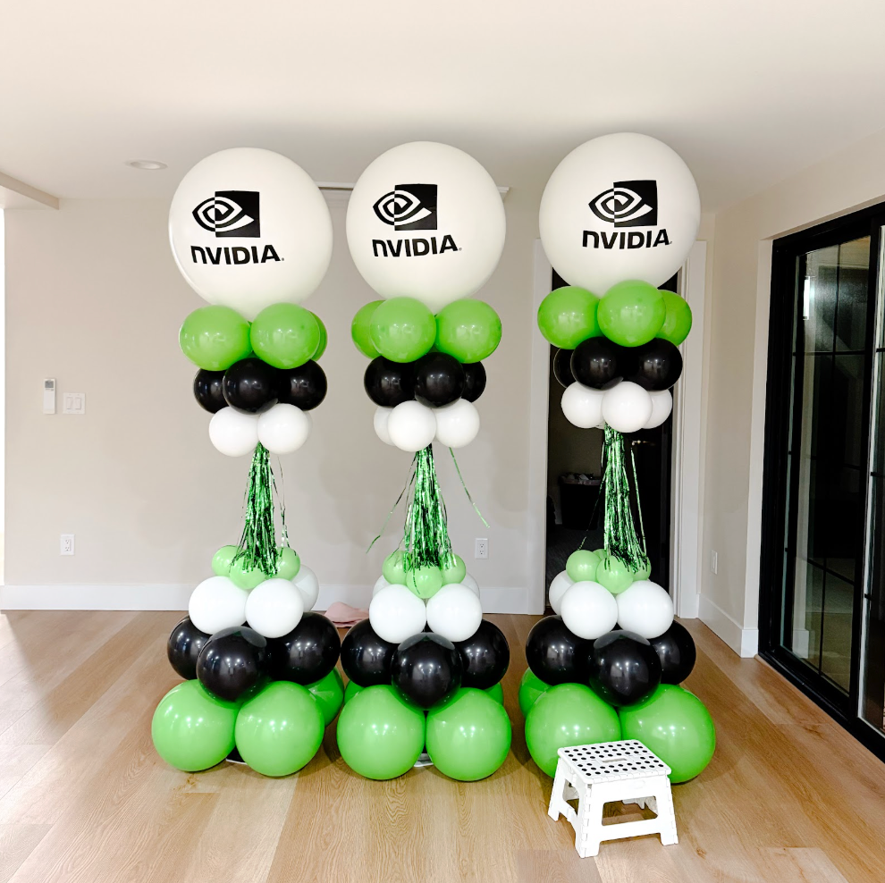 A bunch of balloons are sitting on a wall.
