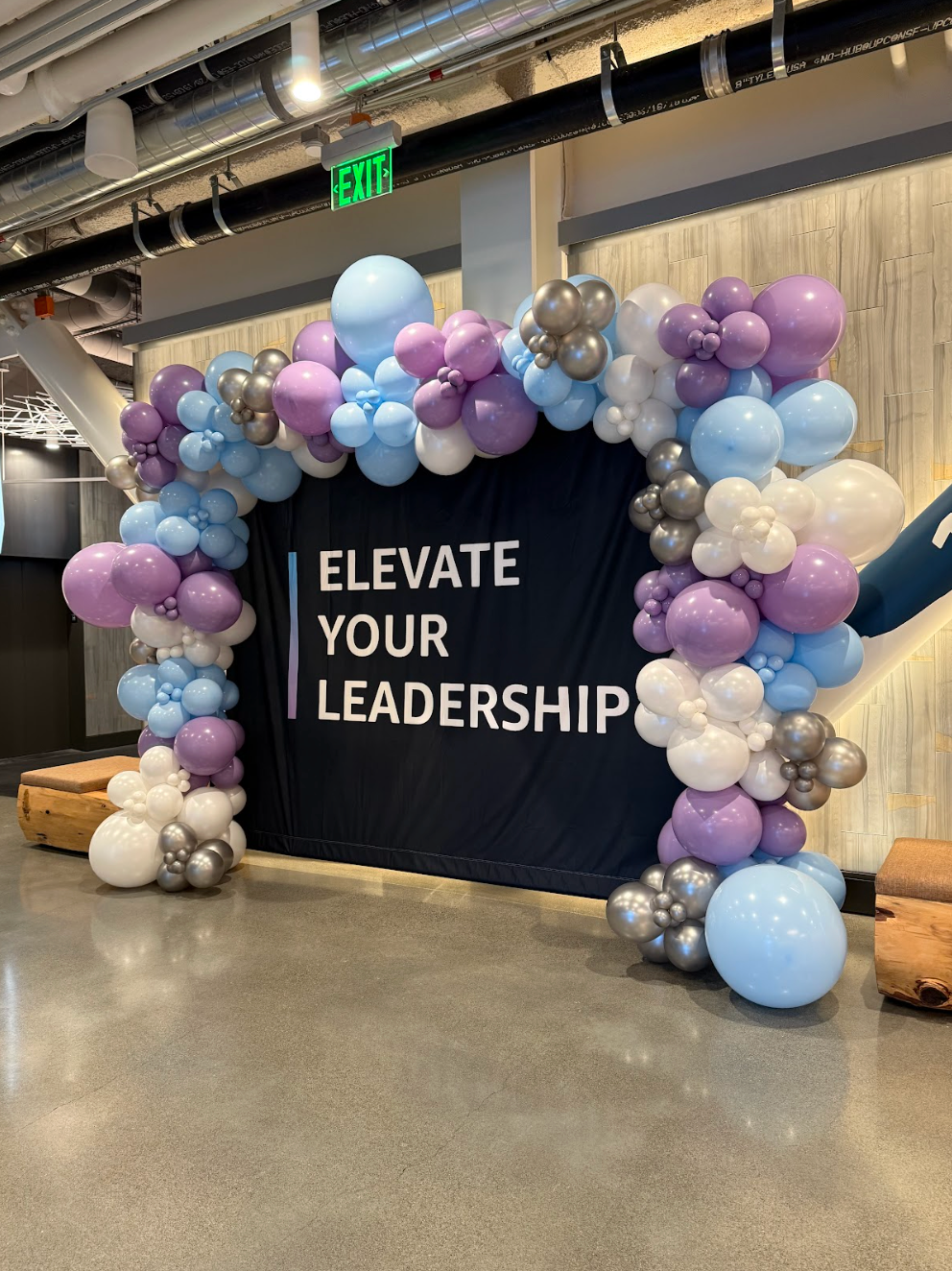 Balloon archway in shades of blue and silver, indoors.