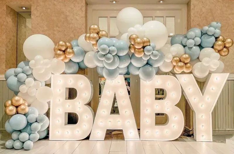 The word baby is surrounded by balloons and lights.