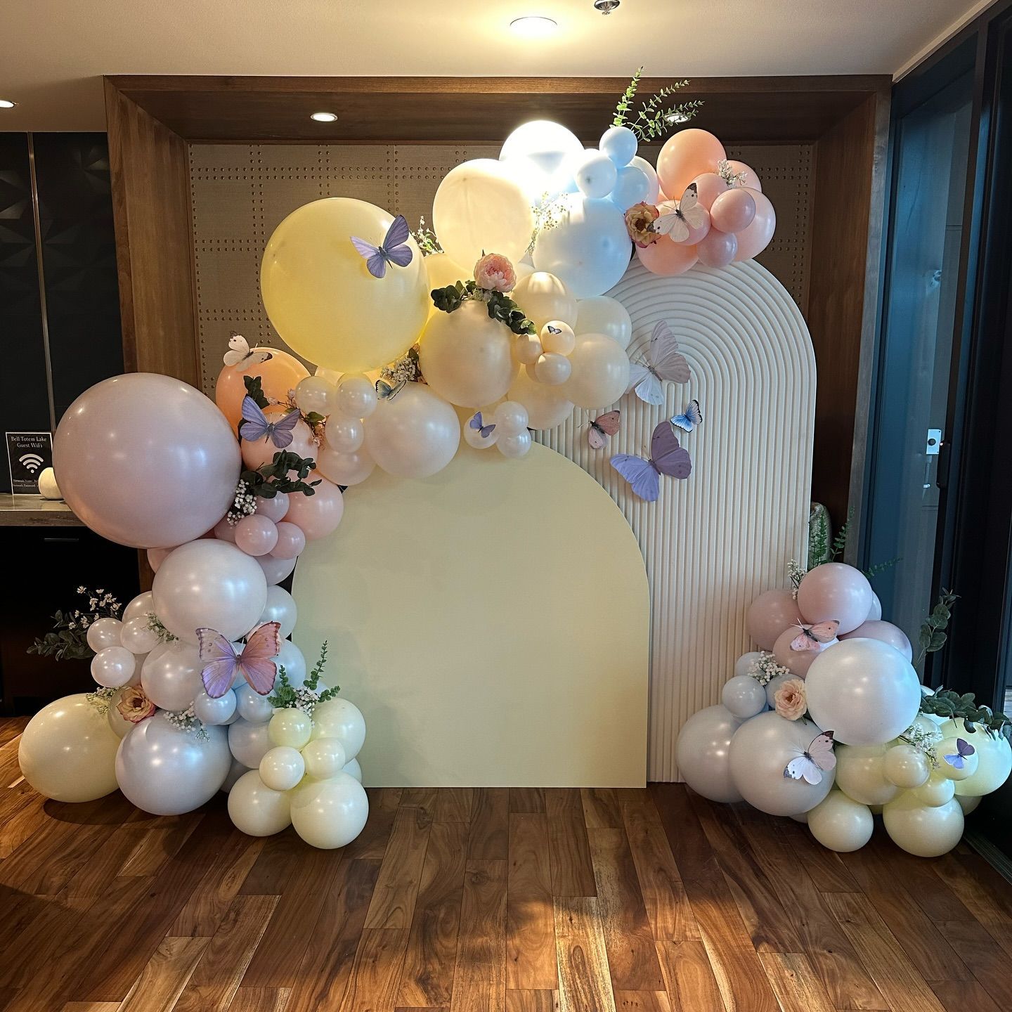 A room filled with balloons and flowers on a wooden floor.