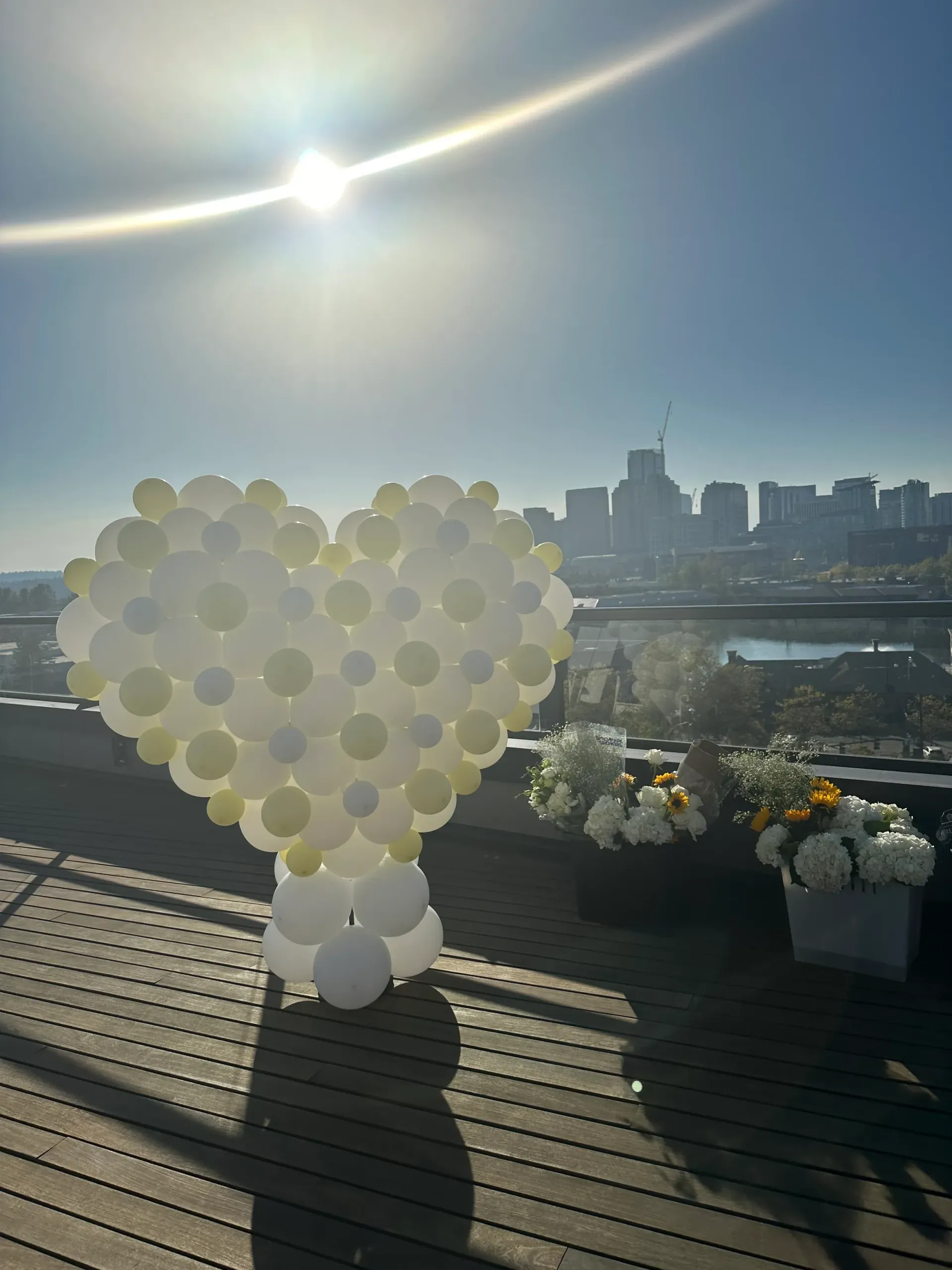 A heart made of balloons is sitting on a wooden deck.