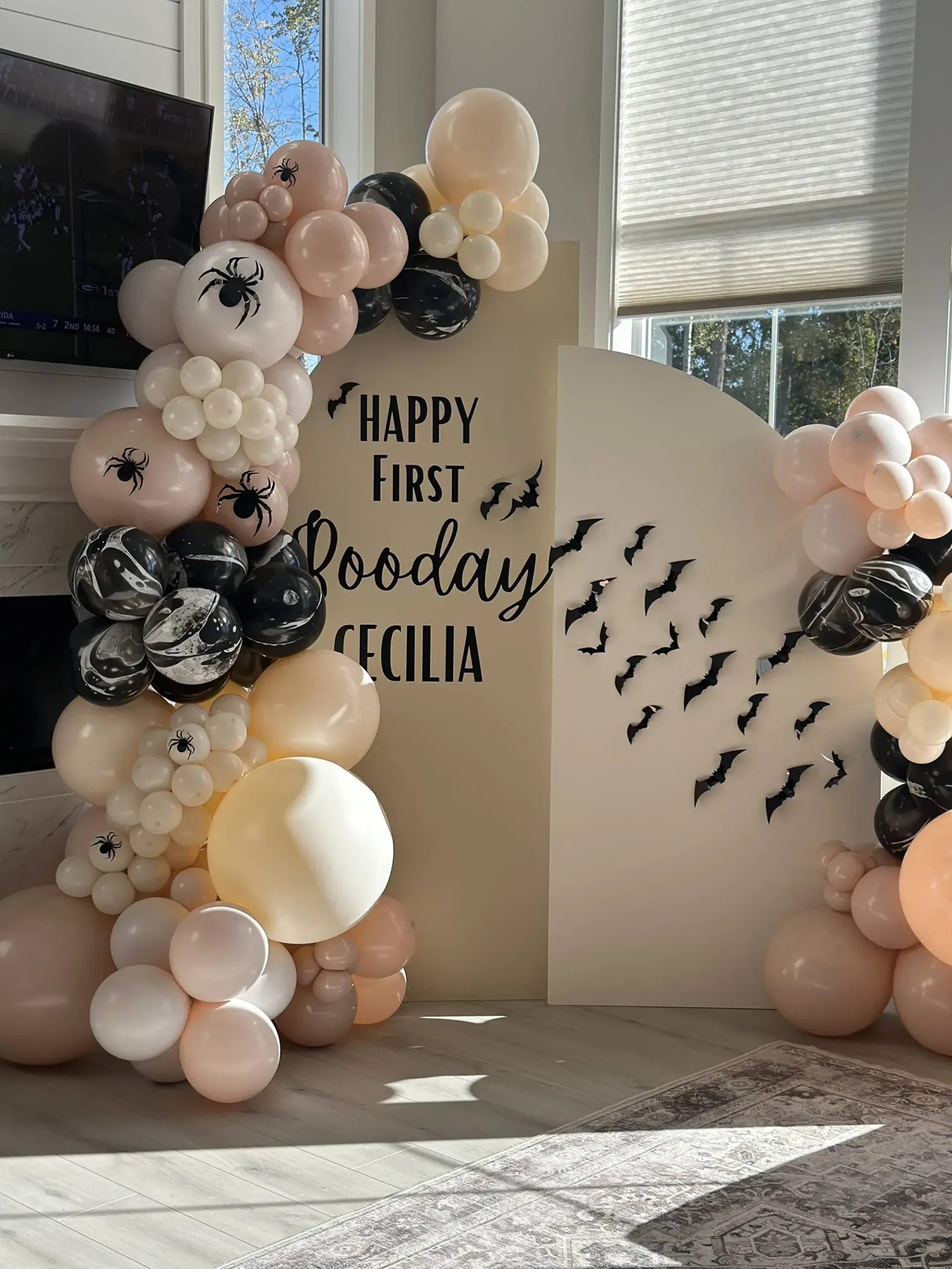 A room filled with balloons and a sign that says happy first birthday