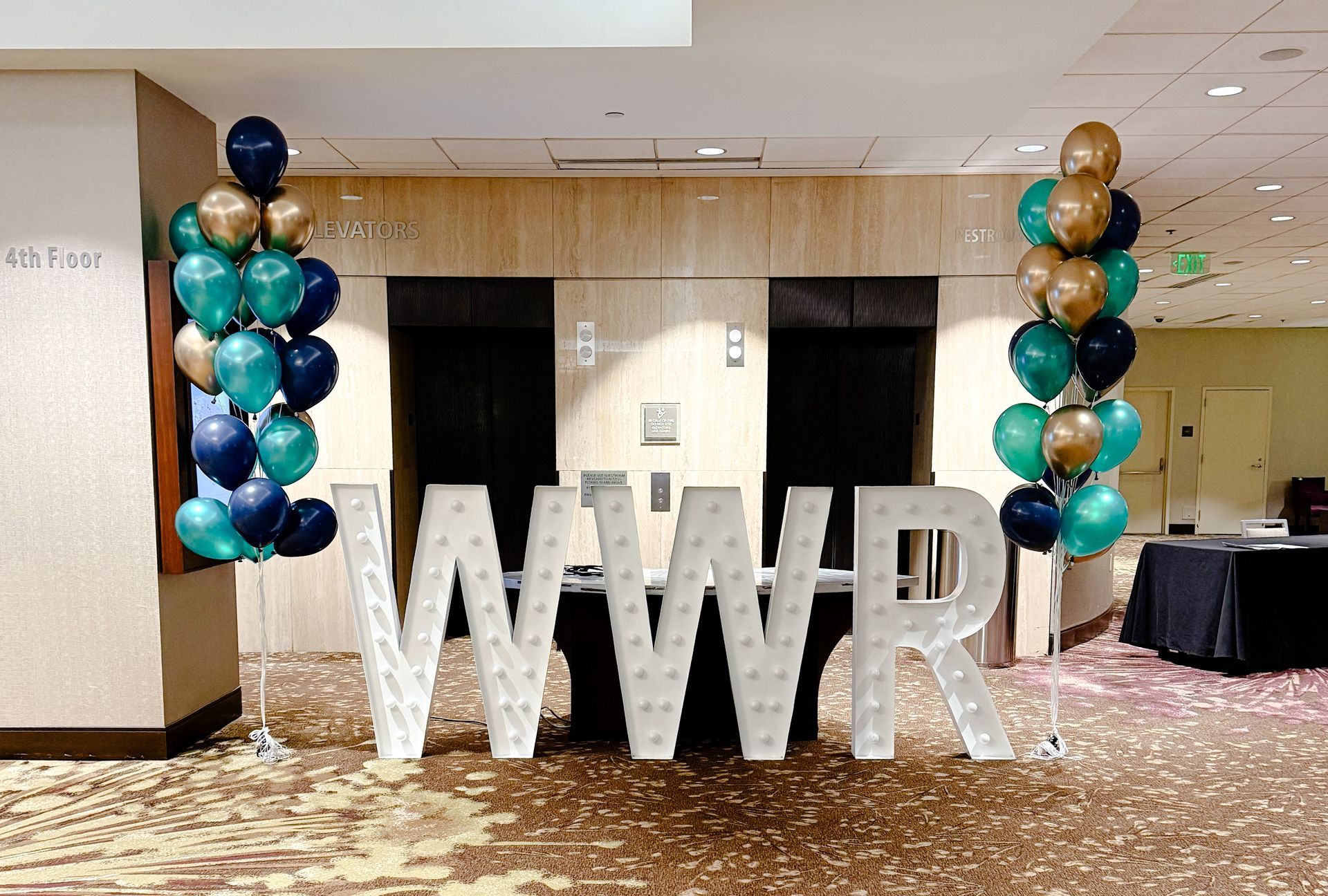A room with balloons and large letters that say wwr
