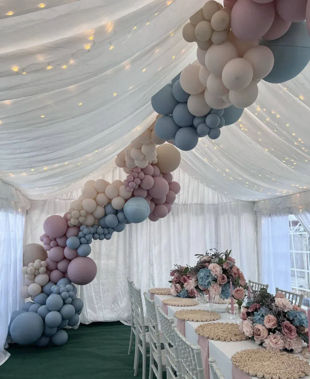 A tent with balloons and flowers hanging from the ceiling