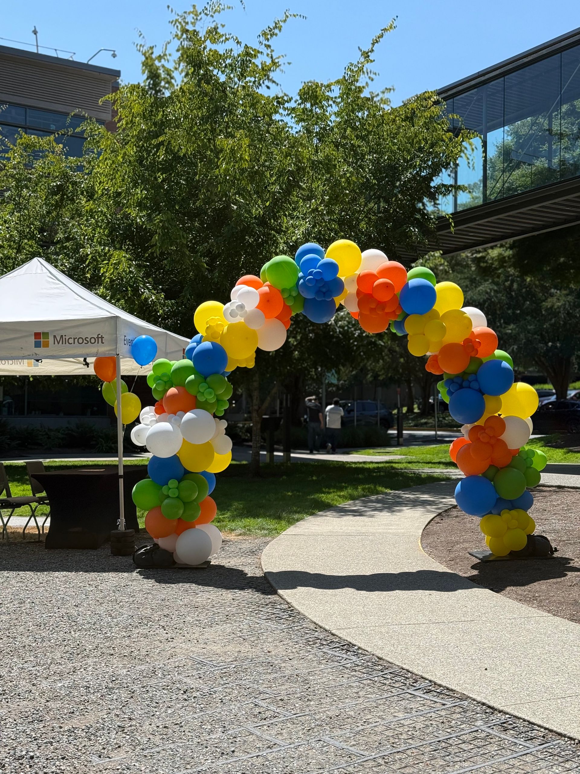 Colorful balloon arch at an outdoor event on a sunny day