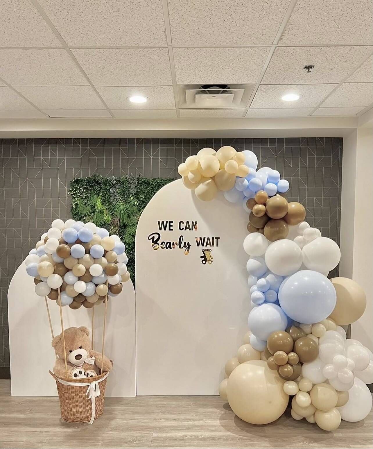 A room filled with balloons and a teddy bear in a basket.